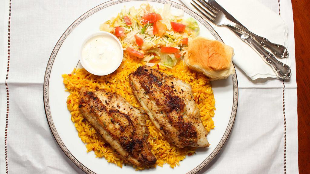 Tilapia Over Rice · One fillet served over a bed of yellow rice with salad.