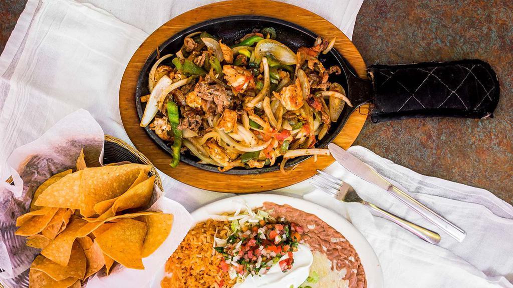 Fajitas Jalisco · Strips of marinated chicken, steak, shrimp, pork tips, chorizo, beef tips, onions, bell peppers and tomatoes. Garnished with lettuce, guacamole, sour cream and pico de gallo. Served with rice, beans and tortillas.