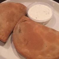 Meat Pies · Two seasoned ground meat turnovers fried to perfection served with spicy mayo and a side.