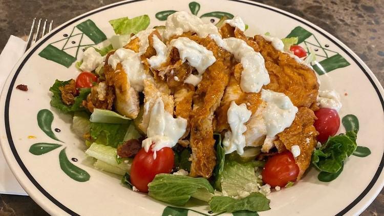 Buffalo Chicken Salad · Romaine, bleu cheese crumbles, applewood smoked bacon, tomato, house-made bleu cheese dressing and topped with our hand-breaded buffalo tenders.