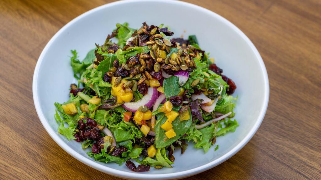 Caramelized Mango Salad · Gluten free vegetarian. mixed greens sweet and spicy mangoes marinated carnberries spiced pumpkin seeds red onions champagne vinaigrette.