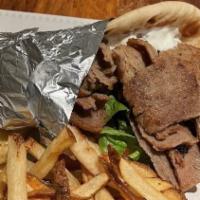 Traditional Gyro Sandwich · Seasoned lamb and beef topped with lettuce, tomatoes, onion and tzatziki wrapped in pita bre...