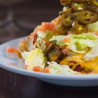 Chicken Nachos · Seasoned chicken smothered in queso, topped with pico de gallo and sour cream