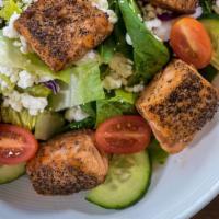 Salmon Salad · Our perfectly seared salmon atop a bed of baby spinach and romaine, grape tomatoes and cucum...
