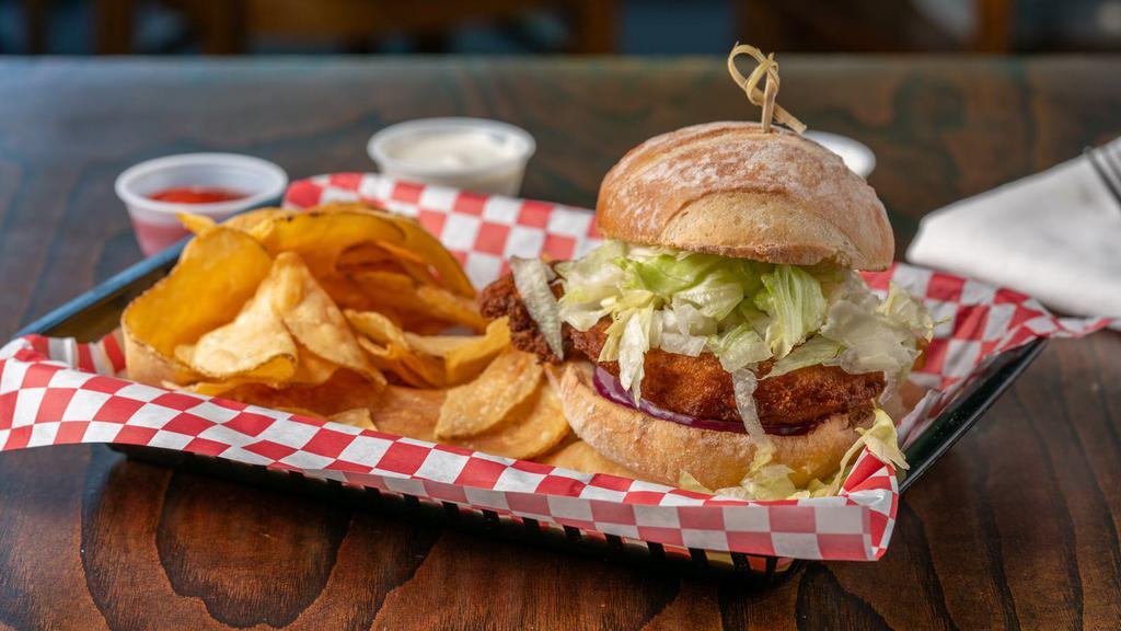 Heavenly Buffaloes Sandwich · Fried chicken breast patty(can sub Vegan patty) with iceberg lettuce,  red onion and your choice of ranch or blue cheese, served on a toasted brioche bun. Comes with a side of our house made chips. 
** Have your breast tossed in one of our signature flavors!  **