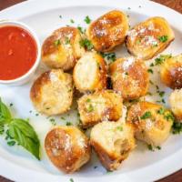 Garlic Knots · Basket of homemade dough in knots tossed in garlic and oil, seasonings and topped with cheese.