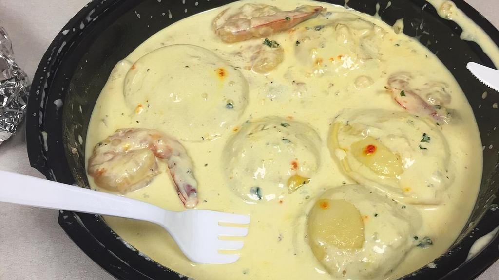 Lobster Ravioli · Ravioli stuffed with lobster in a creamy homemade saffron sauce topped with jumbo shrimp.