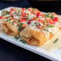 Chimichangas · Two flour tortillas fried or soft filled with chicken or beef. Topped with cheese sauce. Ser...