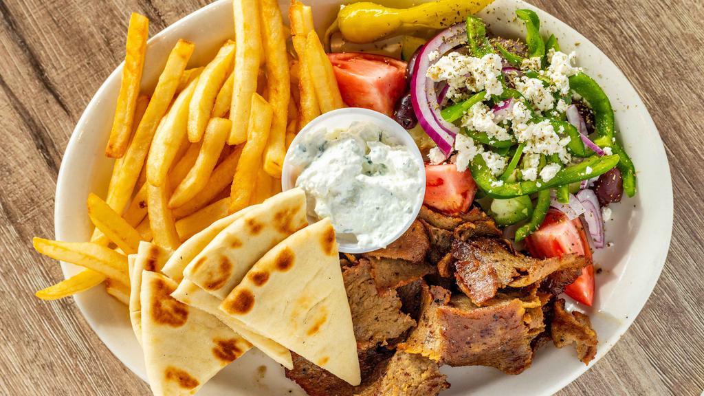 Gyro Dinner · Gyro slices served with Greek salad and fries with tzatziki sauce and pita bread.