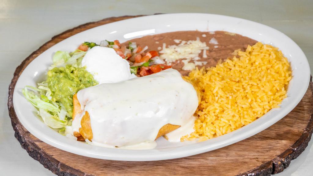 Chimichanga Dinner · Shredded chicken or ground beef topped with cheese sauce, lettuce, sour cream, guacamole, pico de gallo. Served with rice and beans.