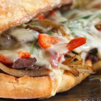 Philly Cheesesteak Sub · Sliced rib eye, lettuce, tomato, mayonnaise, mushrooms, onions, green peppers, and cheese.