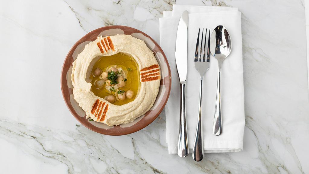 Hummus · A blend of chickpeas, tahini and fresh lemon juice served with extra virgin olive oil.