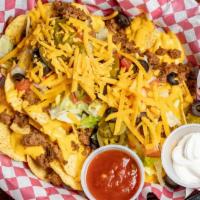 Loaded Nacho’S · A bed of crisp corn tortillas covered with  nacho cheese,our own beef taco meat, lettuce, to...