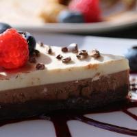 Dulce Amor · coconut fudge, vanilla, cashews, pecan crust topped cacao nibs and berry coulis