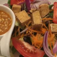 Mai Thai House Salad · Lettuce, tomatoes, cucumbers and carrots topped with fried tofu served with peanut dressing.