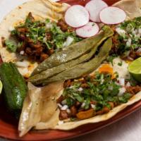 Taqueria Tacos · Your choice of protein on a corn tortilla served with onions and cilantro.