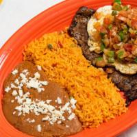 Carne Ranchera · Grilled skirt steak, topped with two huevos ranchero’s and ranchero sauce. Served with Mexic...