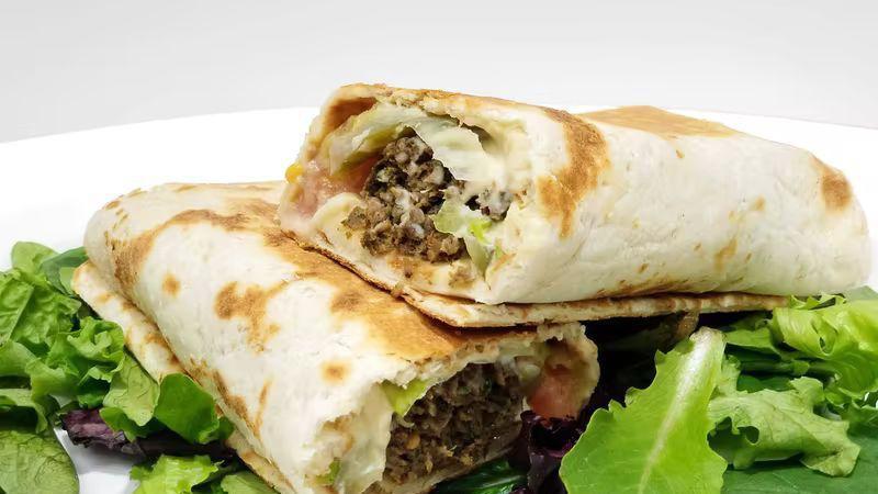 Falafel Sandwich · Wrapped in fresh bread with tahini, tomato, pickles, and lettuce.