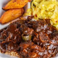 Oxtails · Hefty plate of beef ox tails simmered in brown Jamaican spices served over a bed of rice and...