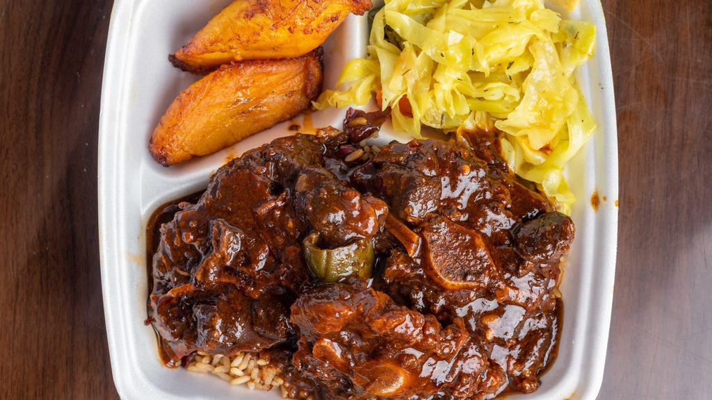 Oxtails · Hefty plate of beef ox tails simmered in brown Jamaican spices served over a bed of rice and peas.