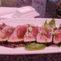 Pepper Tuna · Seared pepper tuna with ponzu sauce and spring mix salad on the bottom.