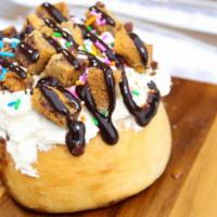 Birthday Bash Cinnamon Roll · Cake batter frosting, chocolate chip cookie bites, sprinkles, and chocolate sauce.