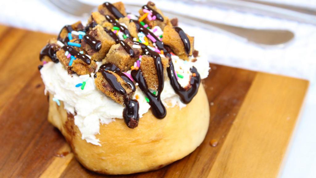 Birthday Bash Cinnamon Roll · Cake batter frosting, chocolate chip cookie bites, sprinkles, and chocolate sauce.