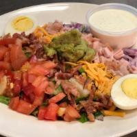 Cobb Salad · Romaine topped with turkey, bacon, boiled egg, guacamole, onion, tomato, cheese, and house d...