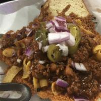Frito Pie Burger · Patty topped with a heap of shredded cheese, our homemade chili, Frito's, diced onion, sour ...