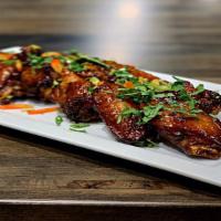 Spicy Fried Hot Wings (8) · Gluten-free. Spicy.  Seasoned and tossed in tangy spicy sauce,  topped with sweet mini peppe...