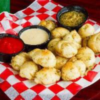 Vegan Garlic Knots · Traditional pizza dough tied into knots, baked and painted with garlic oil. Served with mari...