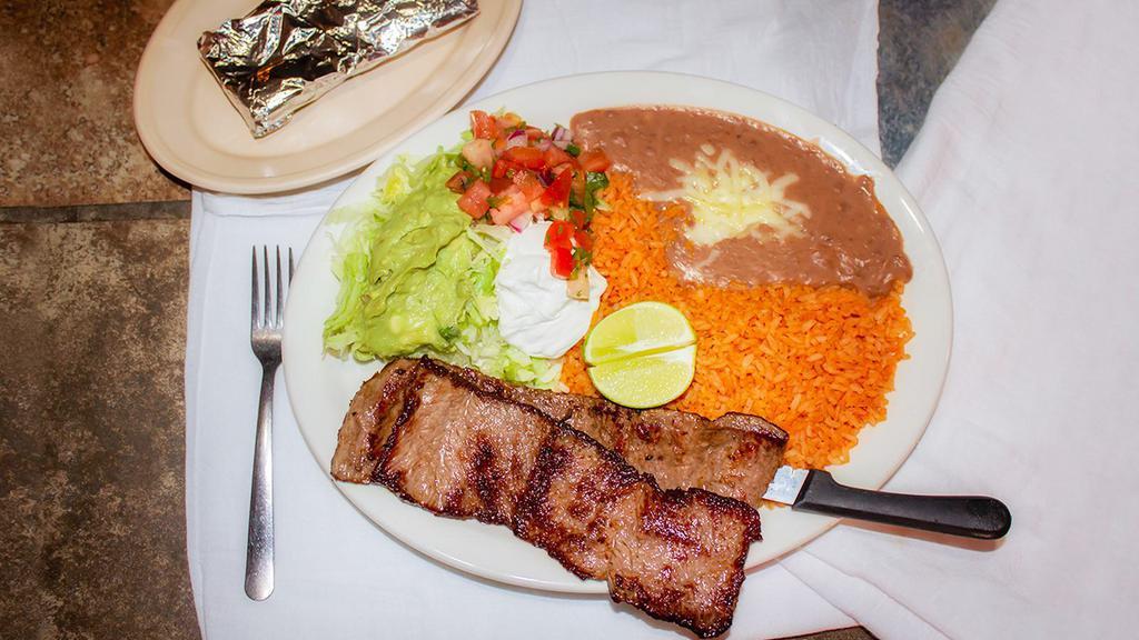 Carne Asada · Steak served with rice and beans, salad and tortillas.