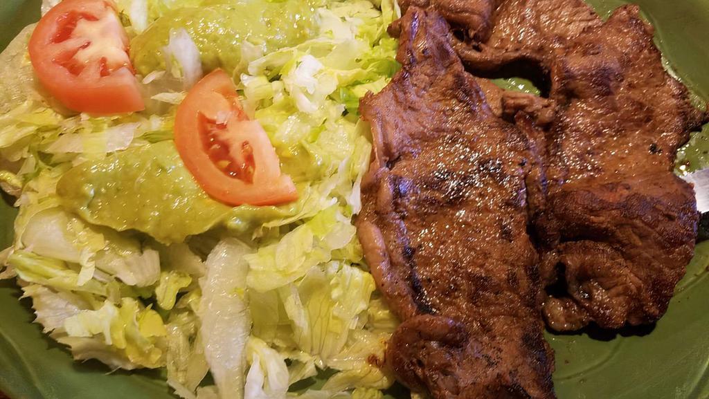 Carne Asada · Tender roast beef with refried beans, Spanish rice, guacamole salad, flour tortillas and green salsa.