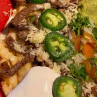 Carne Asada Fries · French fries smothered in queso and topped with tender steak, sour cream, guacamole, pico de...