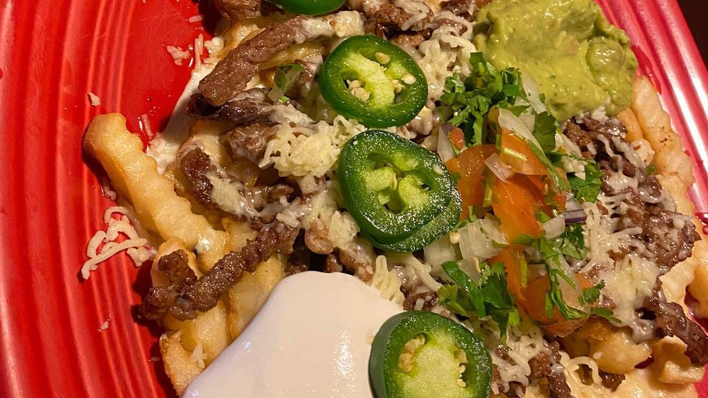 Carne Asada Fries · French fries smothered in queso and topped with tender steak, sour cream, guacamole, pico de gallo, and jalapeño peppers.