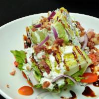 Wedge Salad · Iceberg lettuce, bacon, Tomatoes, Red Onions, Blue Cheese Crumbles w/ Balsamic Glaze & Blue ...