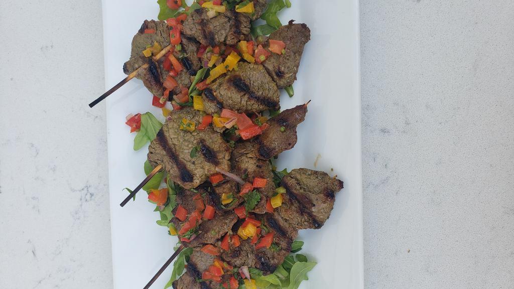 Bocados De Carne · Four steak skewers marinated with chimichurri, served with homemade pico and arugula