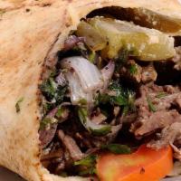 Shawarma Meat Sandwich · Pita wrap with beef shawarma, pickle, onion, parsley and tahini sauce.