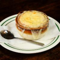 French Onion Soup · A rich & hearty onion-filled broth ladled over bread and topped with melted Swiss cheese.