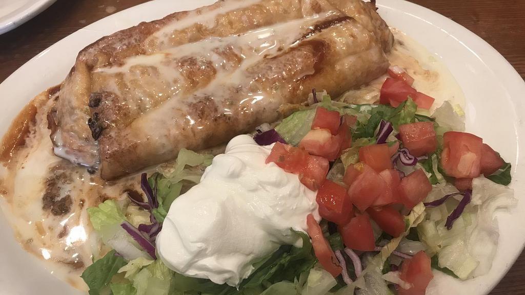 Mucho Burrito · Large tortilla filled with shredded chicken or beef, deep fried with rice and beans, covered with white cheese, enchilada salsa, lettuce, tomato and sour cream.