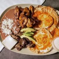 Desayuno Sureño · Fried eggs with fried plantain, cream, cheese, central American chorizo, beans and tortillas.