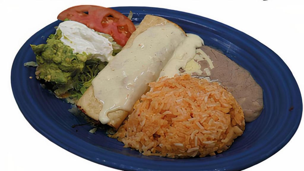 Chimichanga · Fried flour tortilla with beef or chicken, topped with cheese sauce, lettuce, guacamole, sour cream and tomato. Served with rice and beans.
