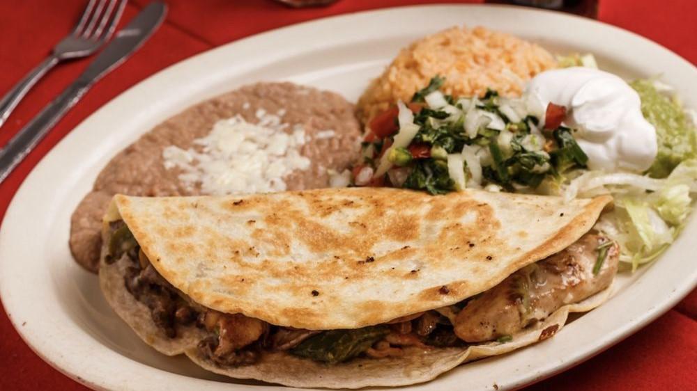 Quesadilla Mexicana · Grilled quesadilla filled with your choice of meat, steak, chicken or shrimp with onions and bell peppers topped with lettuce, pico de gallo, guacamole and sour cream. Served with rice and beans.