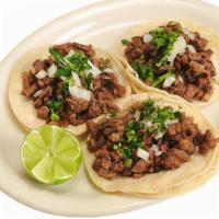 Tacos De Tripa · Three tacos with onions and cilantro.