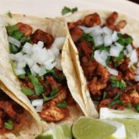 Tacos Al Pastor · Three marinated pork tacos with cilantro, onions & queso dip.