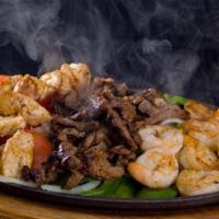 Sizzling Fajitas Texanas · Beef, chicken and shrimp fajitas served with tortillas, rice and beans. Topped with lettuce,...