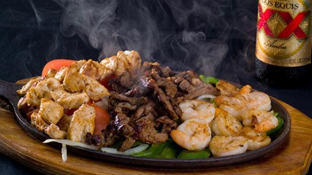 Sizzling Fajitas Texanas · Beef, chicken and shrimp fajitas served with tortillas, rice and beans. Topped with lettuce, sour cream, pico de gallo and guacamole.
