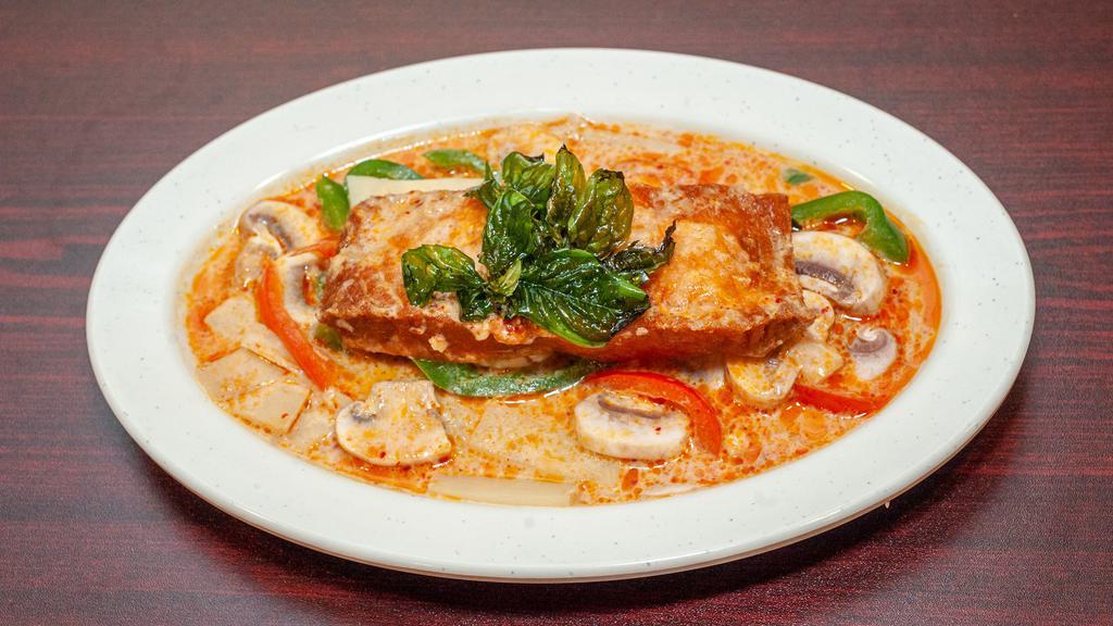Salmon Curry · Seared salmon topped with creamy red curry, bamboo shoots, and bell peppers, topped with basil, and mushrooms.