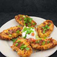 Potato Skins · These spuds are loaded to the hilt with cheddar cheese, bacon and chives. Served with sour c...