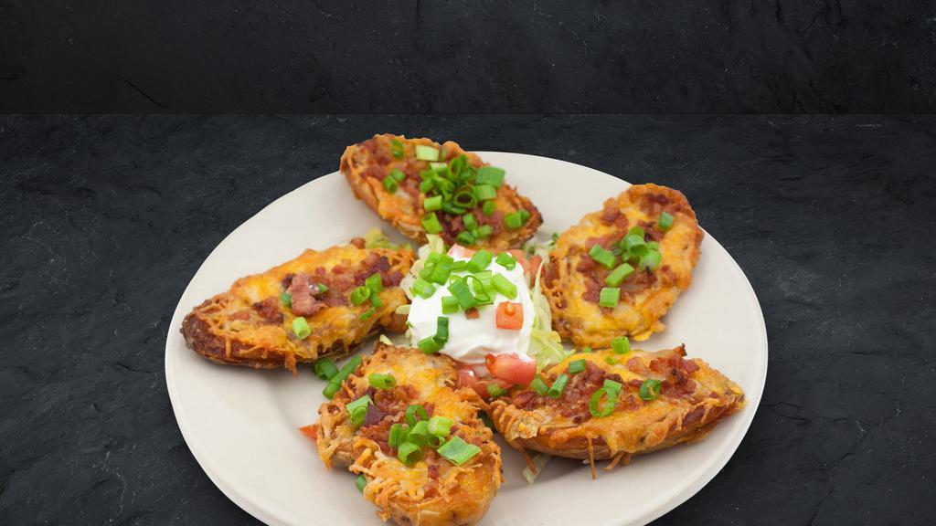 Potato Skins · These spuds are loaded to the hilt with cheddar cheese, bacon and chives. Served with sour cream.